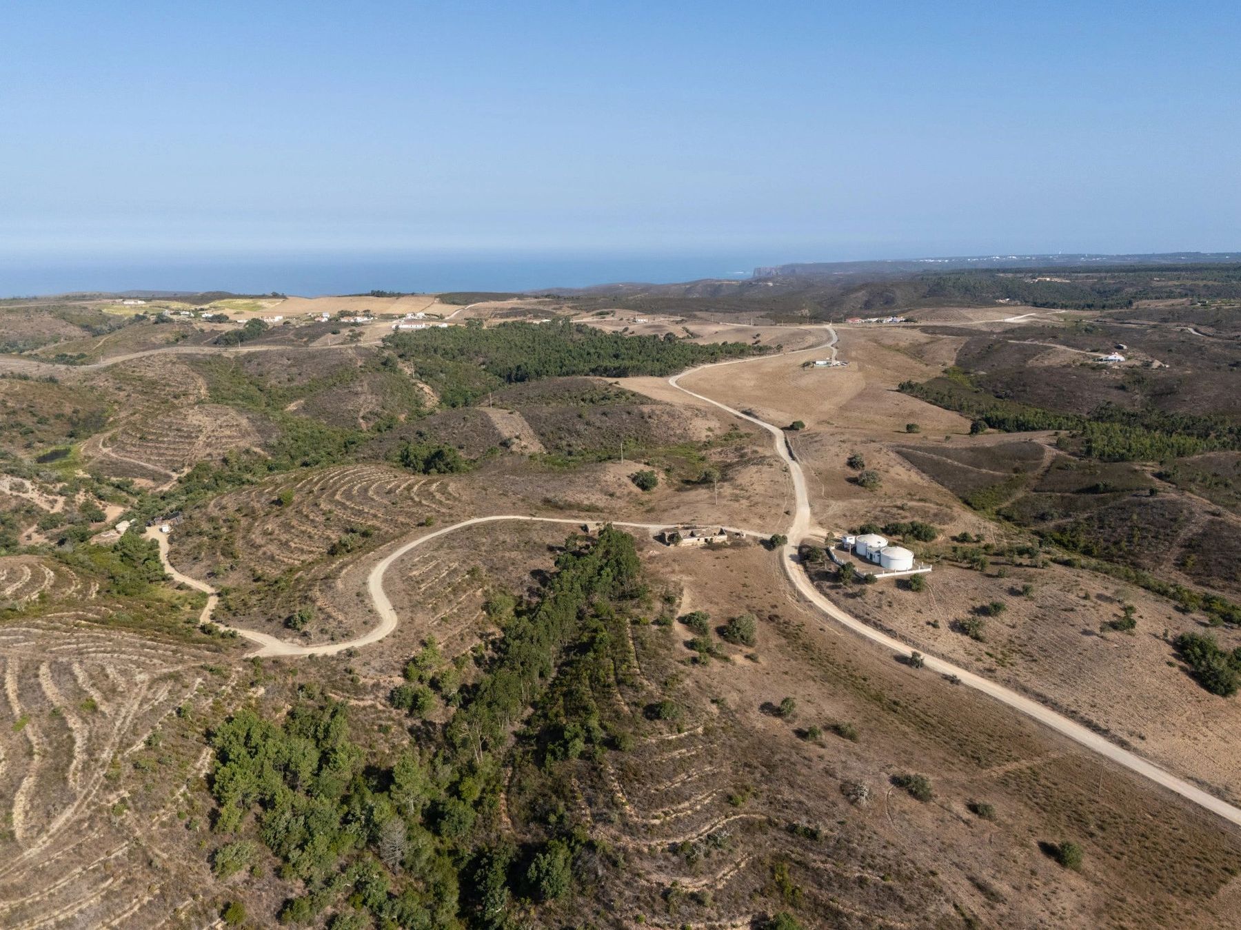 Aerial view over the Alfambras estate towards the Atlantic, with the access track and water tanks